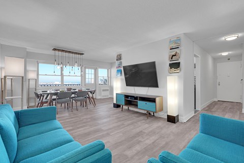 A living room with blue chairs and a television.