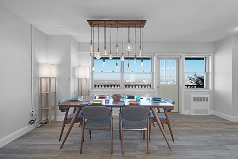 A dining room with a table set for four and a view of the city.