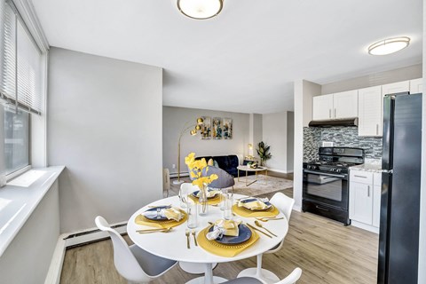A modern dining room with a white table set for two.