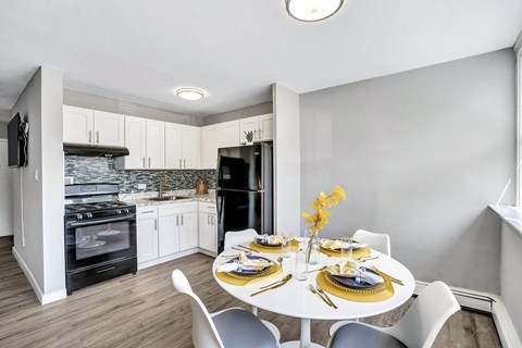 A modern kitchen with a dining table set for two.