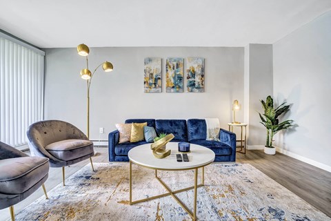 A living room with a blue couch and a gold floor lamp.