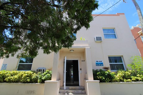 A house with a "For Rent" sign on the front.