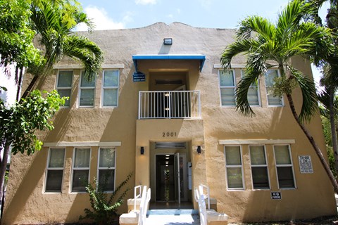 A building with a blue roof and a balcony with white railings.
