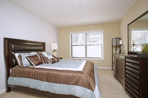 A bedroom with a brown headboard and a blue bedspread.