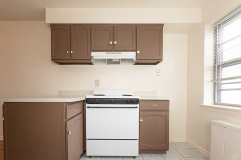 A white dishwasher is in a kitchen with brown cabinets.