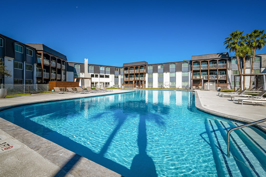 a large swimming pool with a building in the background