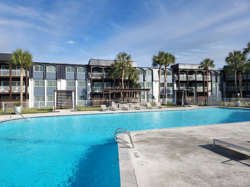 a large swimming pool in front of an apartment building