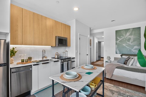 A modern kitchen with a dining table set for two.