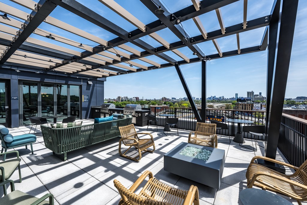 A patio with a table and chairs under a roof.