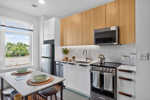 A modern kitchen with a black oven and wooden cabinets.