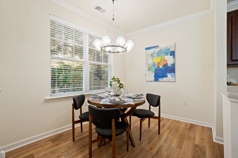 A dining room with a table set for four.