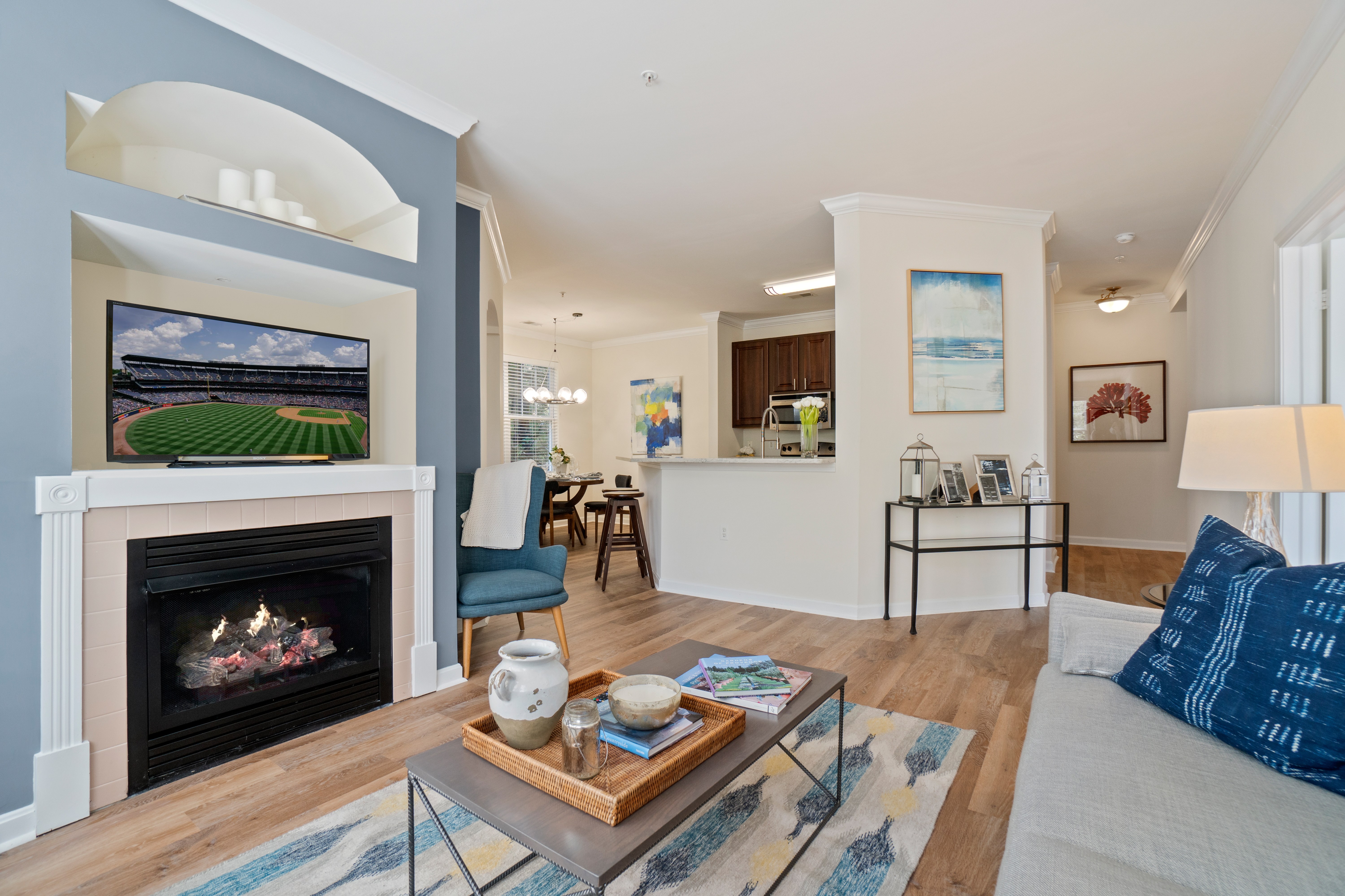 A living room with a fireplace and a painting on the wall.
