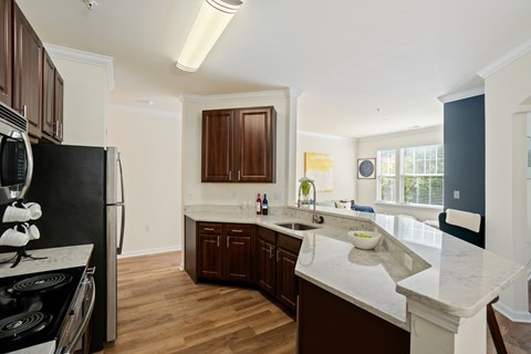 A kitchen with a black refrigerator and wooden cabinets.