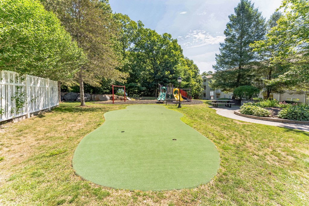 a mini golf course in a backyard with trees and a fence  at Cumberland Crossing, Cumberland, 02864