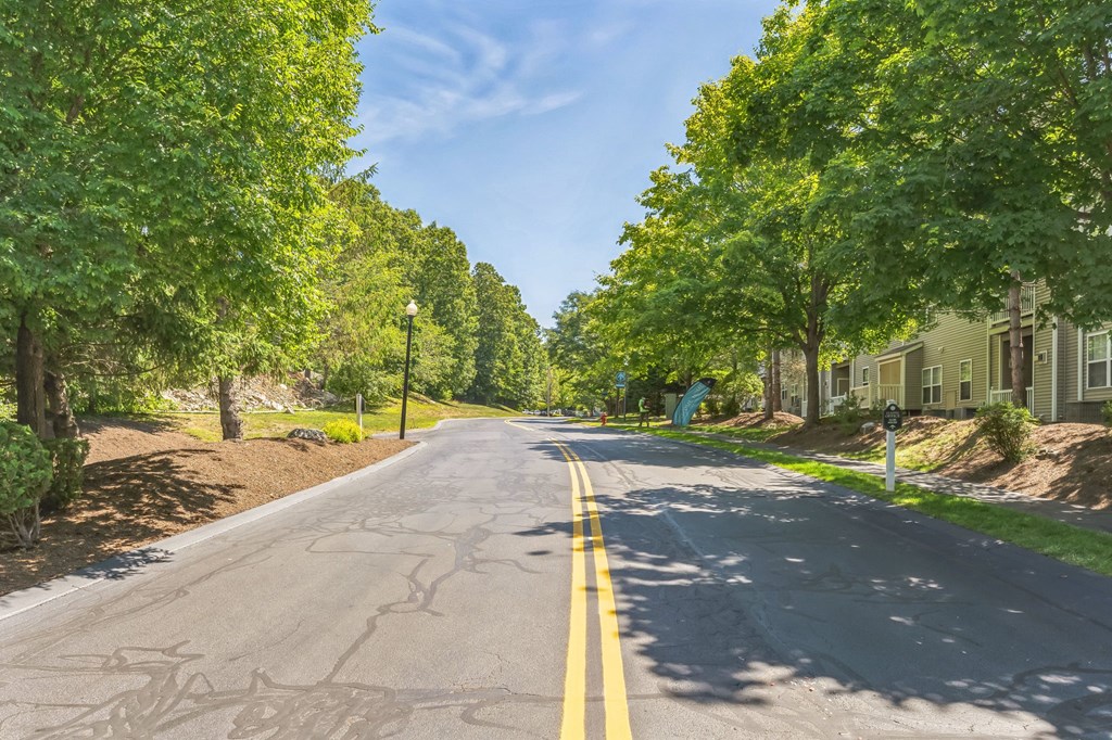 a street with houses and trees on both sides of the road  at Cumberland Crossing, Rhode Island
