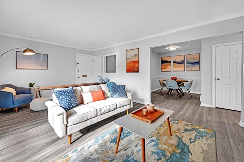 A living room with a white couch and a blue chair.