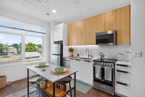 A kitchen with a table set for two with plates and glasses on it.