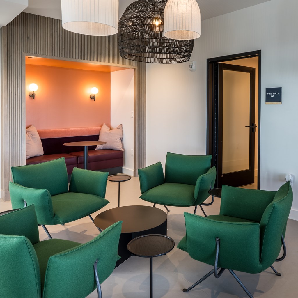 A room with green chairs and a round table.
