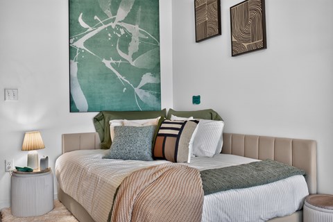 A bedroom with a large bed and two wall art pieces.