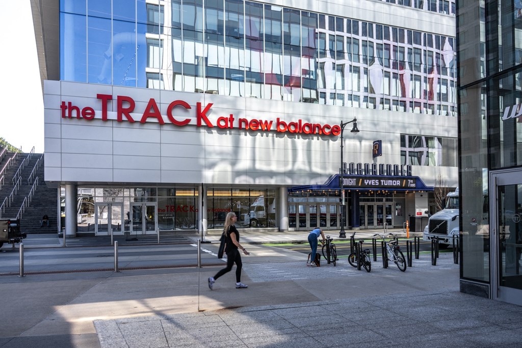A woman walking in front of the TRACK at The Indie, Boston, 02134  
