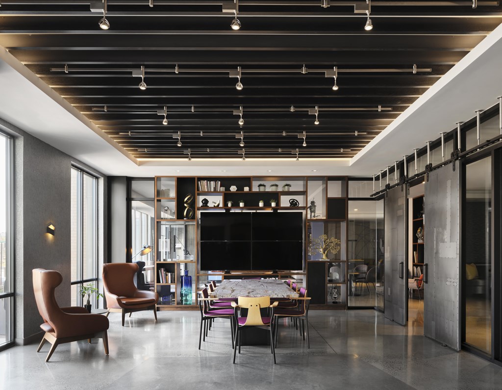 A modern living room with a television and a glass wall.