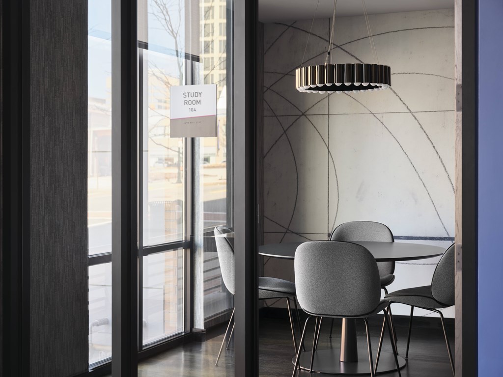 A study room with a table and chairs is visible through a glass door.