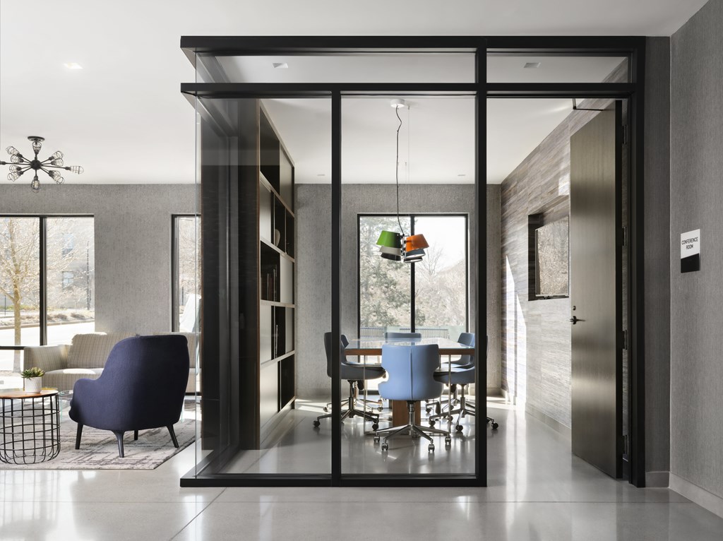 A modern office space with a glass wall and a hanging plant.