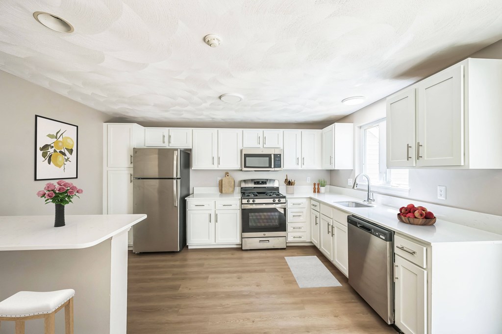 A kitchen with white cabinets and appliances.