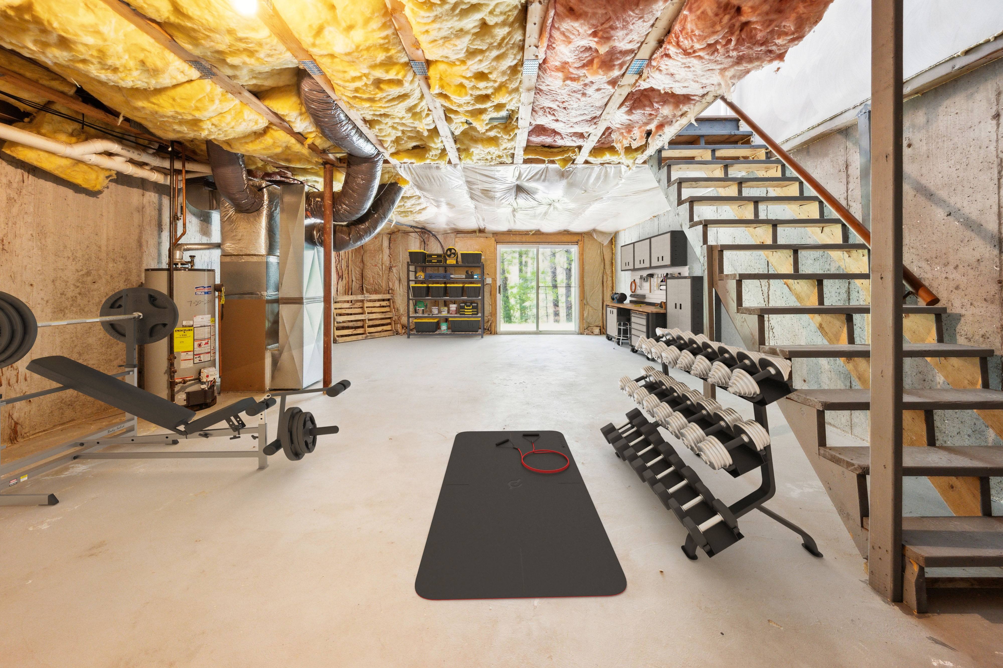 A gym with a variety of equipment including weights and a bench.