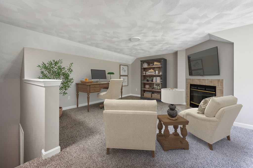 A living room with a fireplace, a couch, a chair, a desk, and a potted plant.