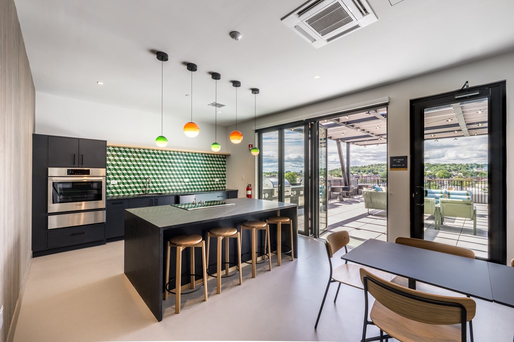 A modern kitchen with a bar area and a view of the outdoors.