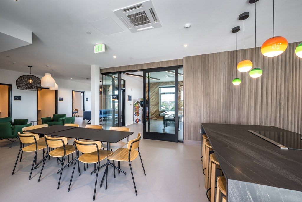A modern dining room with a long table and chairs.