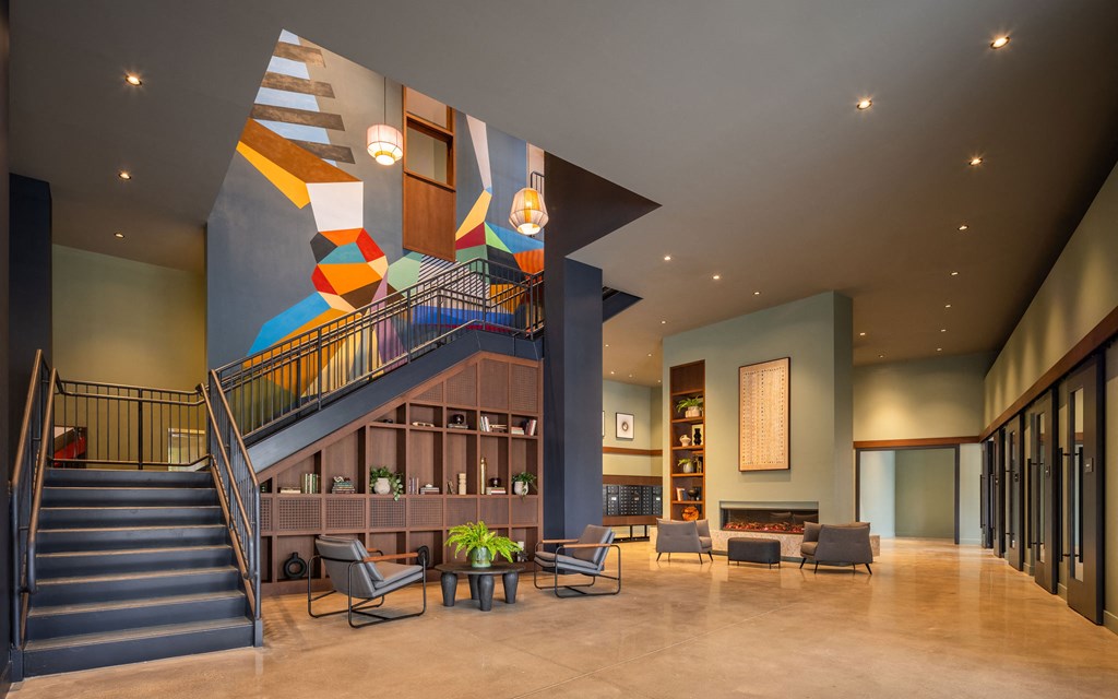 the lobby of a hotel with stairs and a colorful stairwell