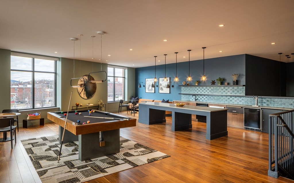 A room with a pool table and a bar.