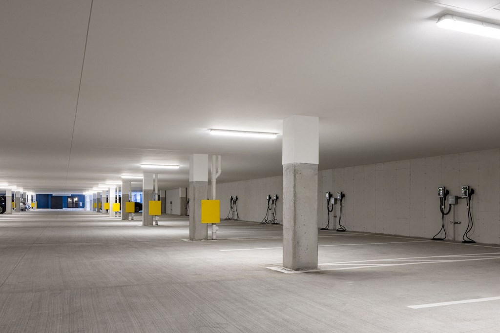 A parking garage with yellow posts and white walls.