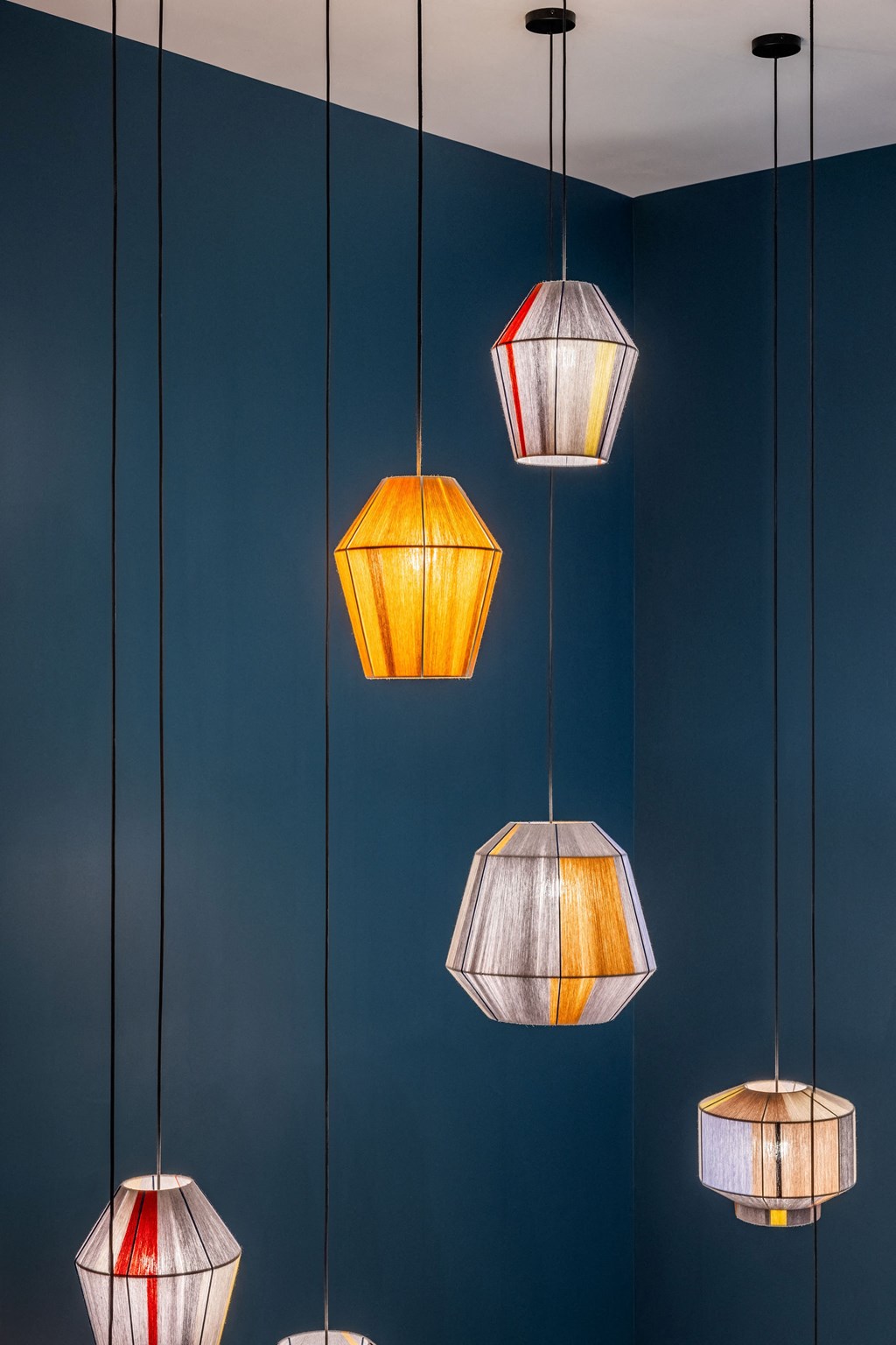 Five hanging lamps with different shapes and designs are suspended from the ceiling.