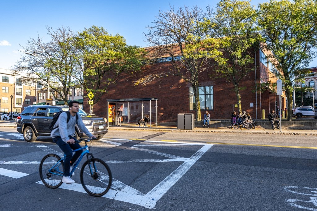 a man riding a bike in a crosswalk on a city street at The Indie, Boston  