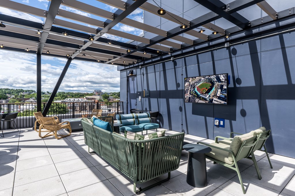 A patio with a couch, chairs, and a painting on the wall.