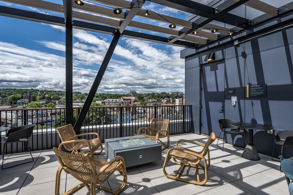 A patio with a table and chairs overlooking a cityscape.
