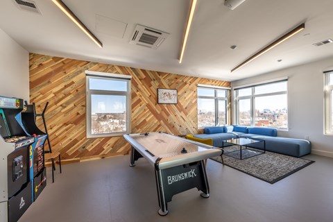 A room with a wooden wall and a pool table.