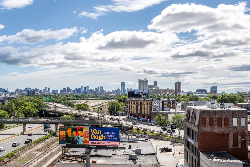 A billboard with the text "Van Gogh Portraits" is visible in the foreground of a cityscape.