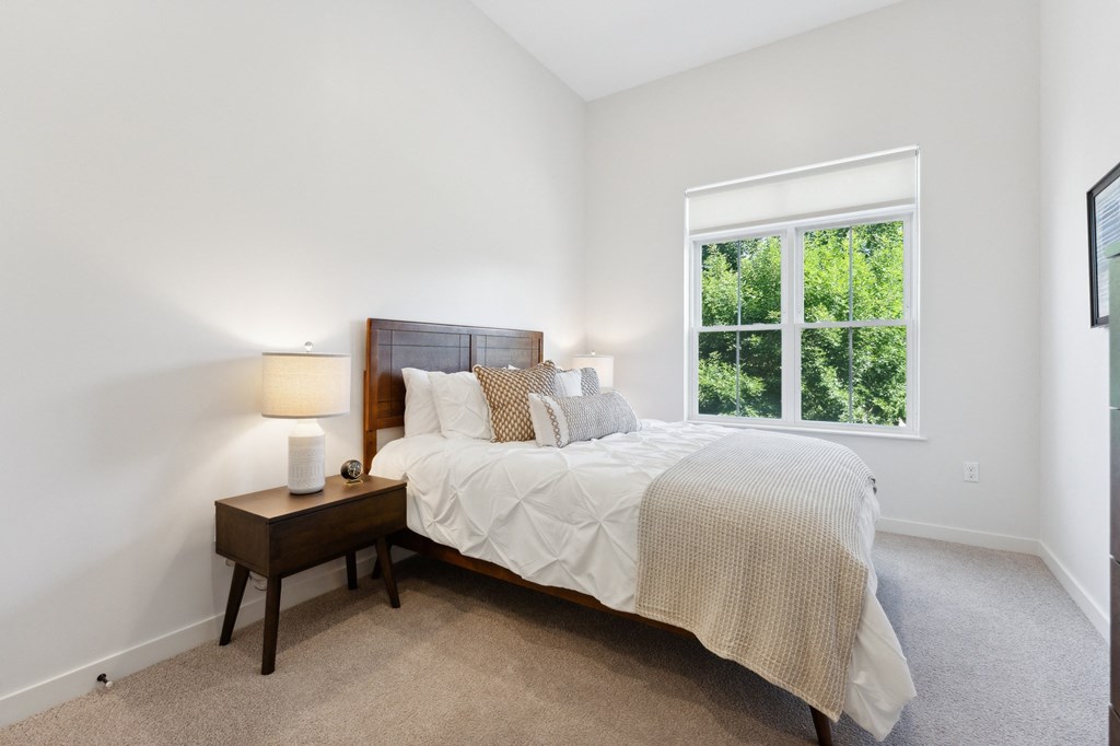 a bedroom with a large bed and a window