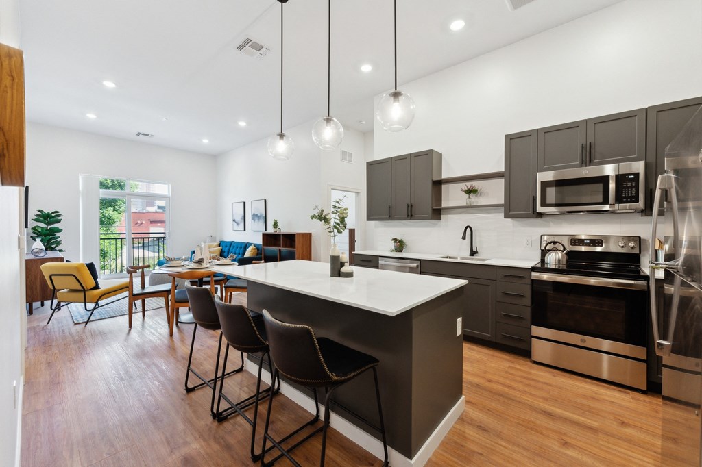 a kitchen with a large island and a dining room with a table and chairs