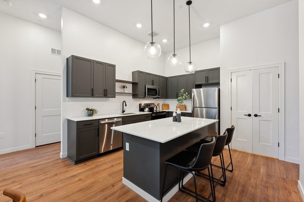 a kitchen with a large island and dark cabinets