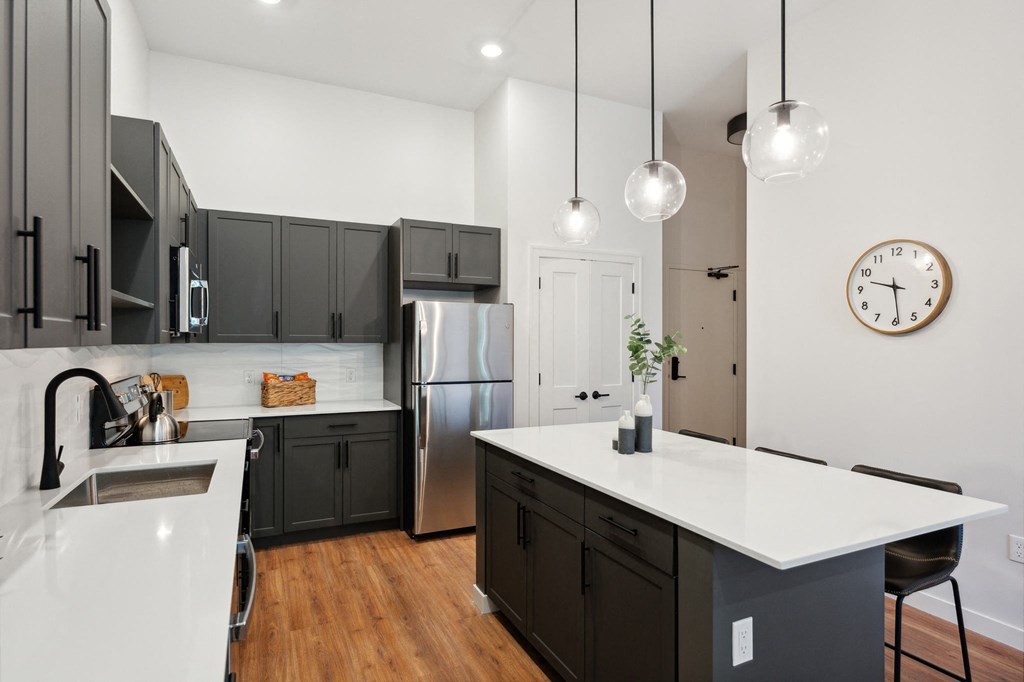 a kitchen with an island and a stainless steel refrigerator