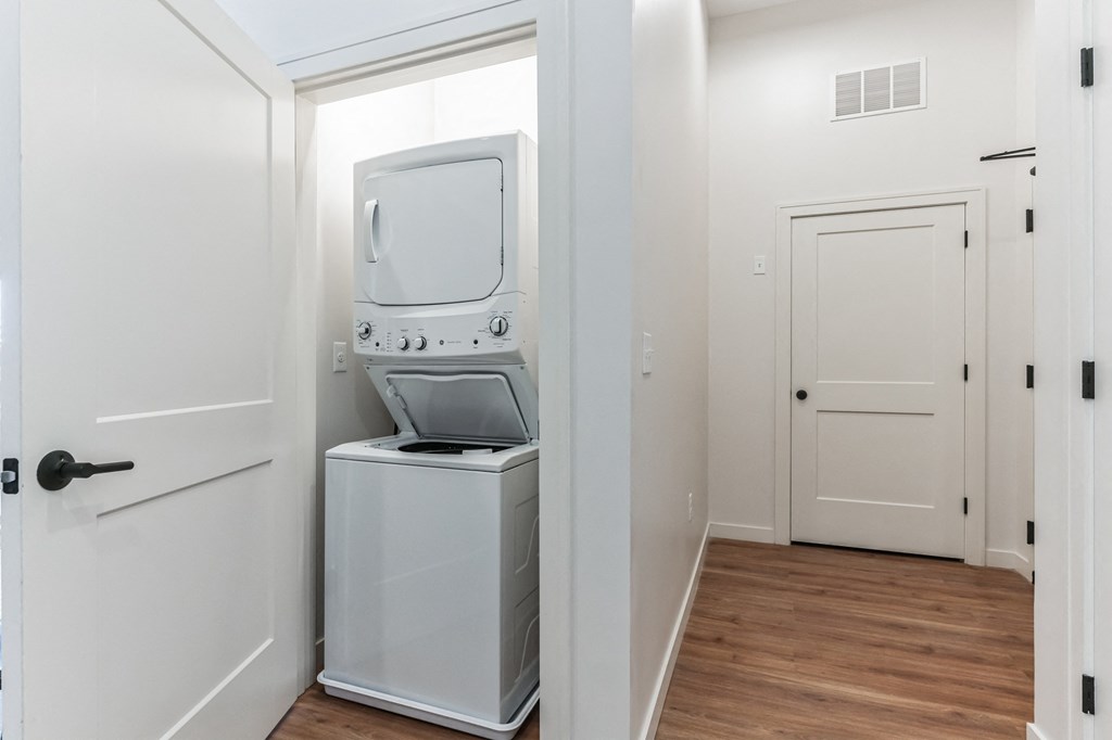 a small laundry room with a washer and dryer and a white door