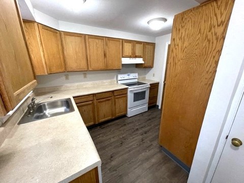 a kitchen with wooden cabinets and a stove and a sink