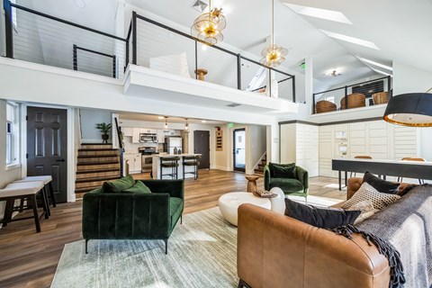 A living room with a green couch and a brown leather chair.