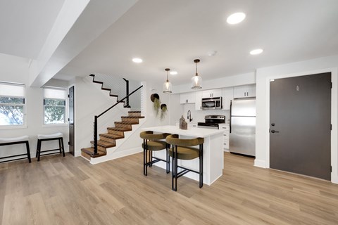 A modern kitchen with a dining table and chairs.