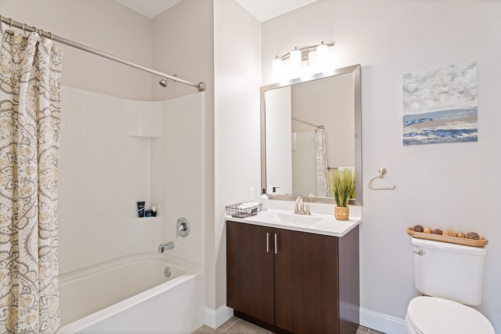 a bathroom with a shower sink and toilet and a mirror